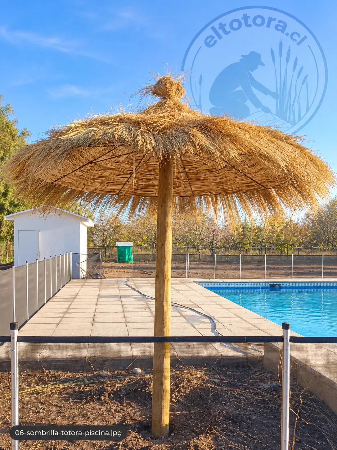 Quitasol de totora junto a piscina